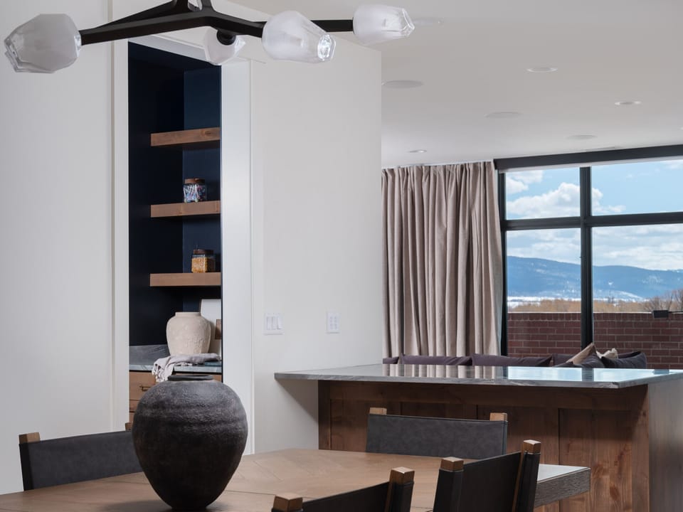 Grand (Penthouse) - Chic dining area with built-in bar and natural light.