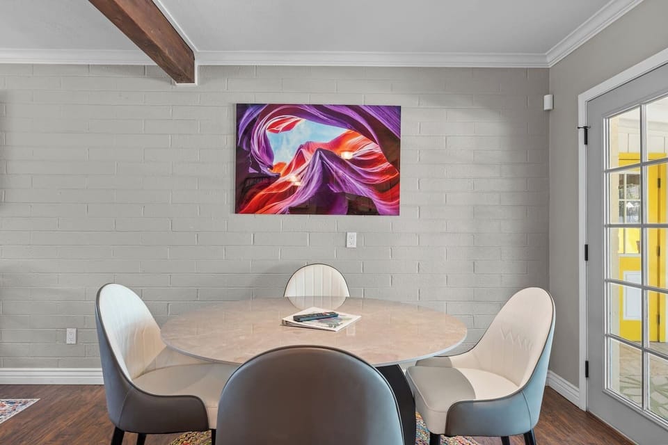 Dining area with round table, mixed seating, and bold Arizona-inspired wall art.