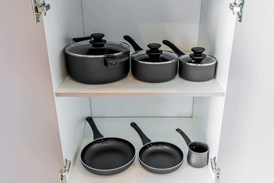 Open drawer with cookware, including pots and pans.