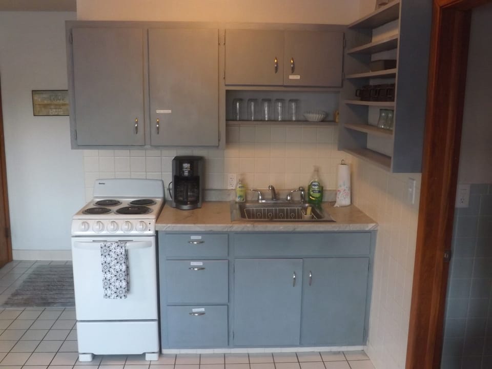 Full kitchen with refrigerator, stove, microwave, coffee makers, and most essentials