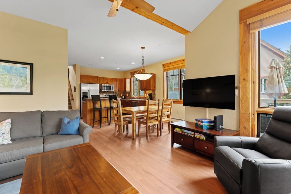 Unwind in your open-concept haven with plush seating, natural wood accents, a full kitchen, and dining for six—perfect for relaxing evenings together after mountain adventures.