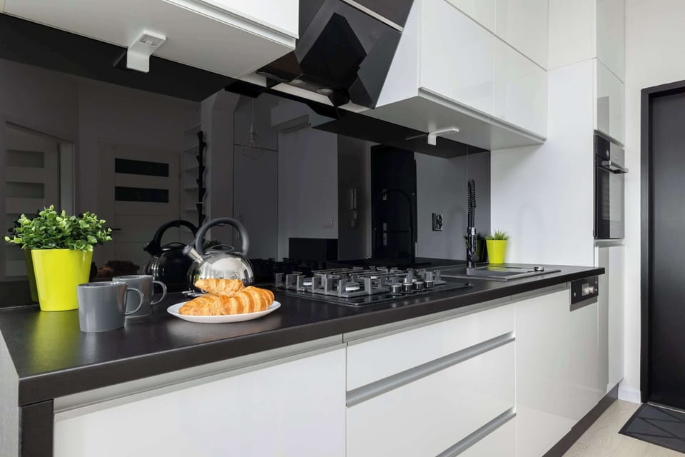 A modern kitchen design featuring glossy black surfaces, state-of-the-art appliances, and minimalist elegance.