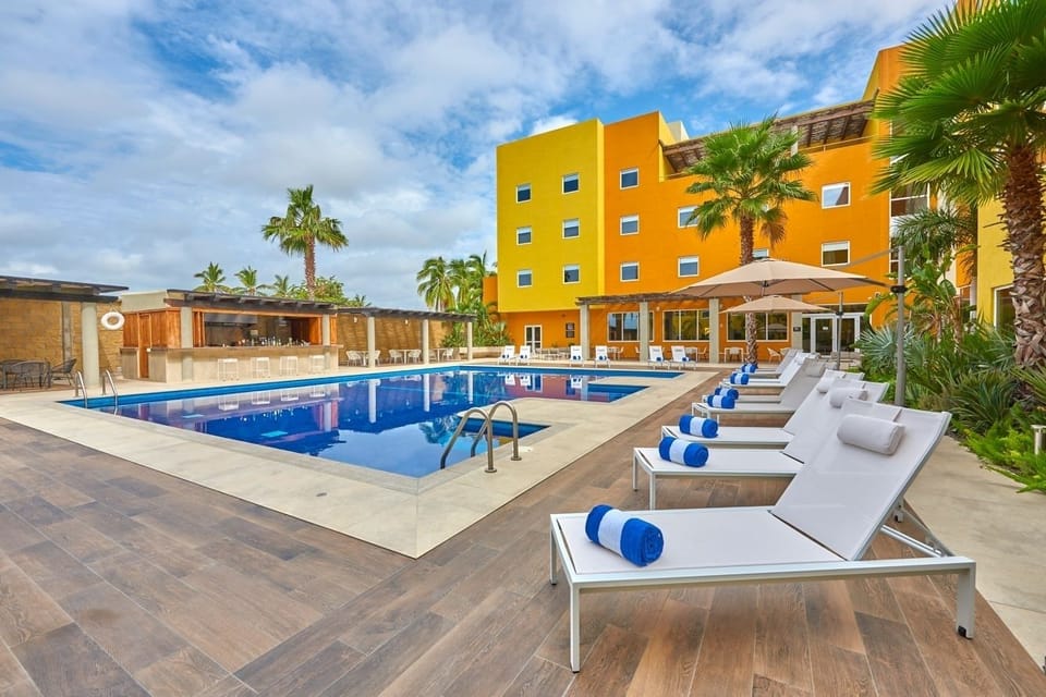 Unwind poolside on plush loungers under warm tropical skies.