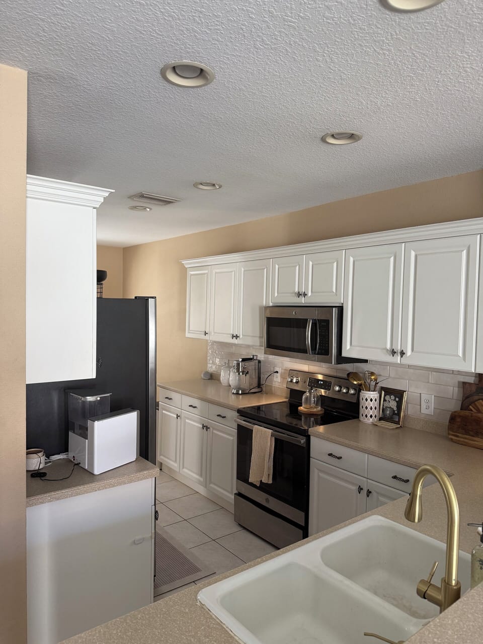 kitchen with fridge, dishwasher, stove, microwave, and espresso machine