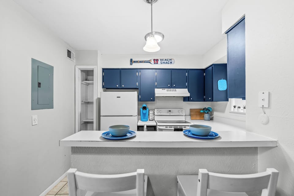 Kitchen equipped with pots, pans, utensils, dishes and a Keurig coffee maker