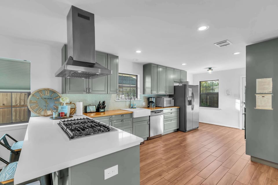 Gray cabinetry, farmhouse sink, and everything you need to prepare meals just like at home. Spacious layout ideal for group cooking.