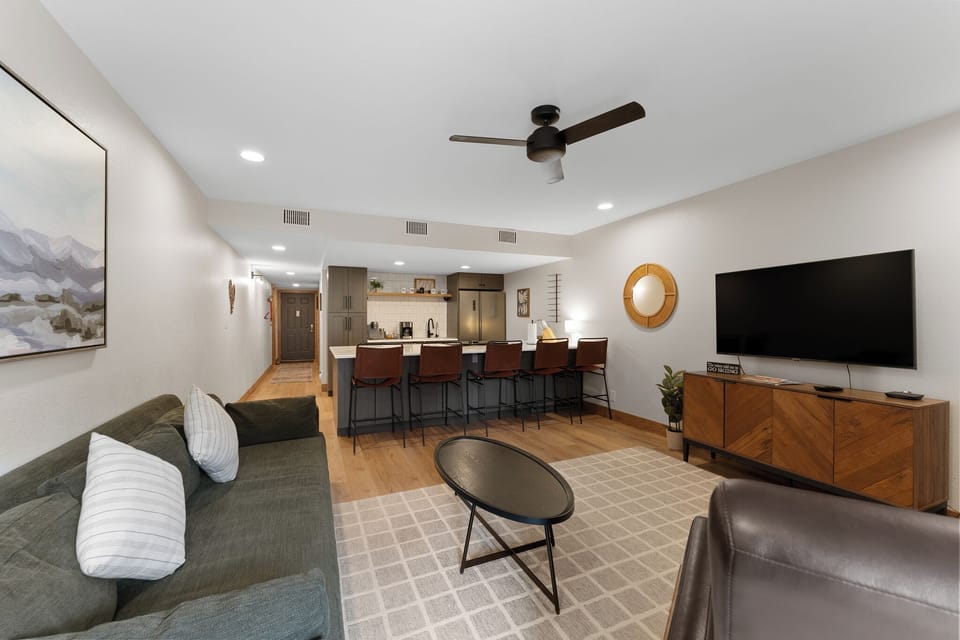 The cozy living area features a wood-burning fireplace, flat-screen TV, and access to the private balcony.