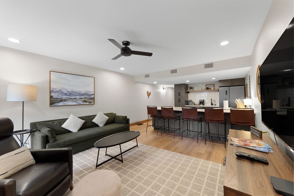 The cozy living area features a wood-burning fireplace, flat-screen TV, and access to the private balcony.