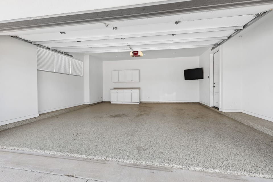 Spacious garage with TV and storage.