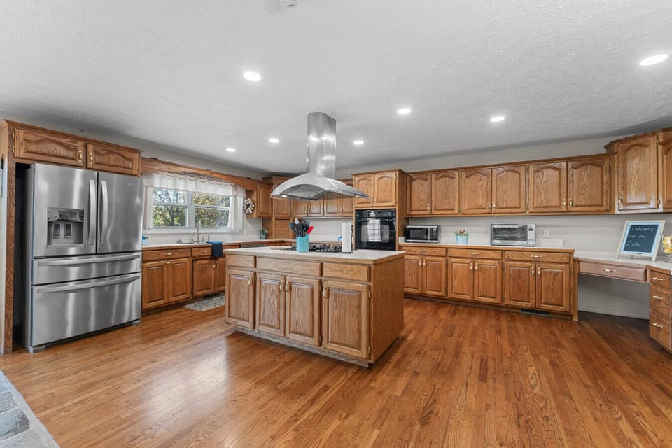 Kitchen | Expansive Space with Oak Cabinetry, Center Island & Stainless Steel Appliances