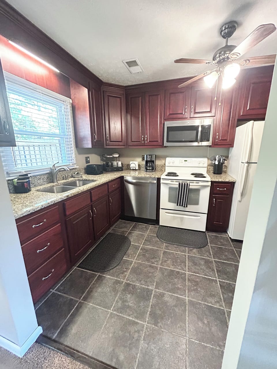 Fully equipped custom kitchen with granite countertop and solid cherry cabinets.