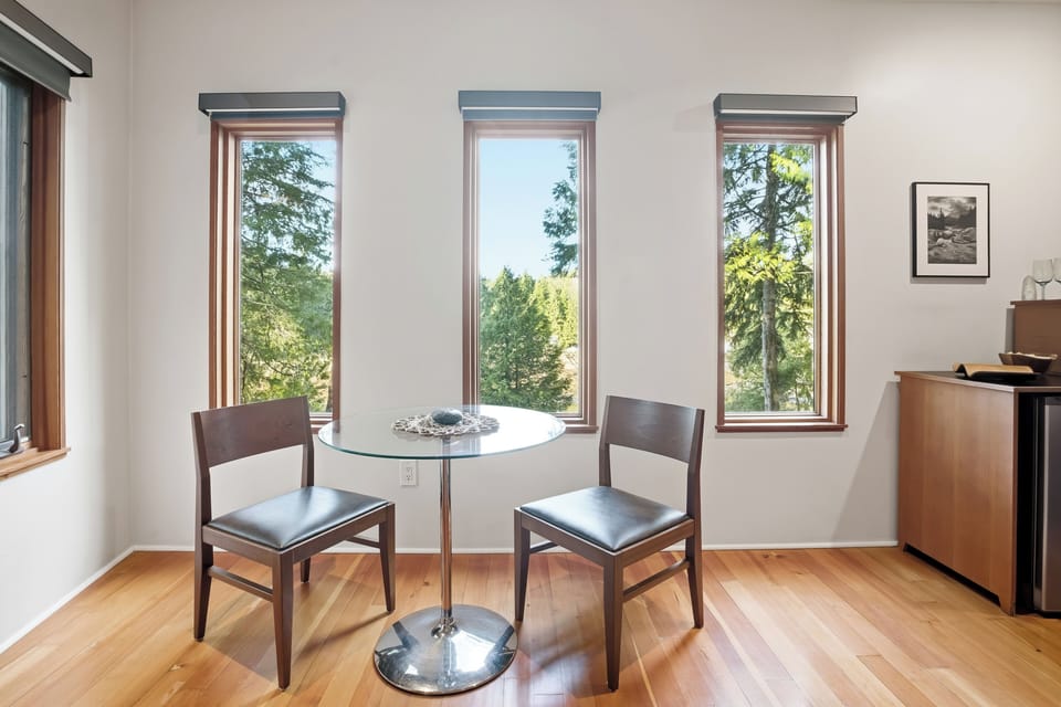 Sunny nook with forest views, bistro table, and sleek hardwood floors