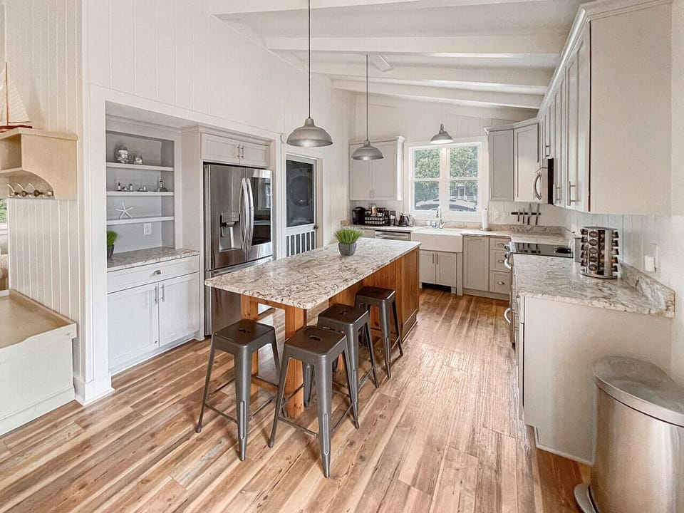 Large fully stocked chefs kitchen with huge island is ready for meals together.