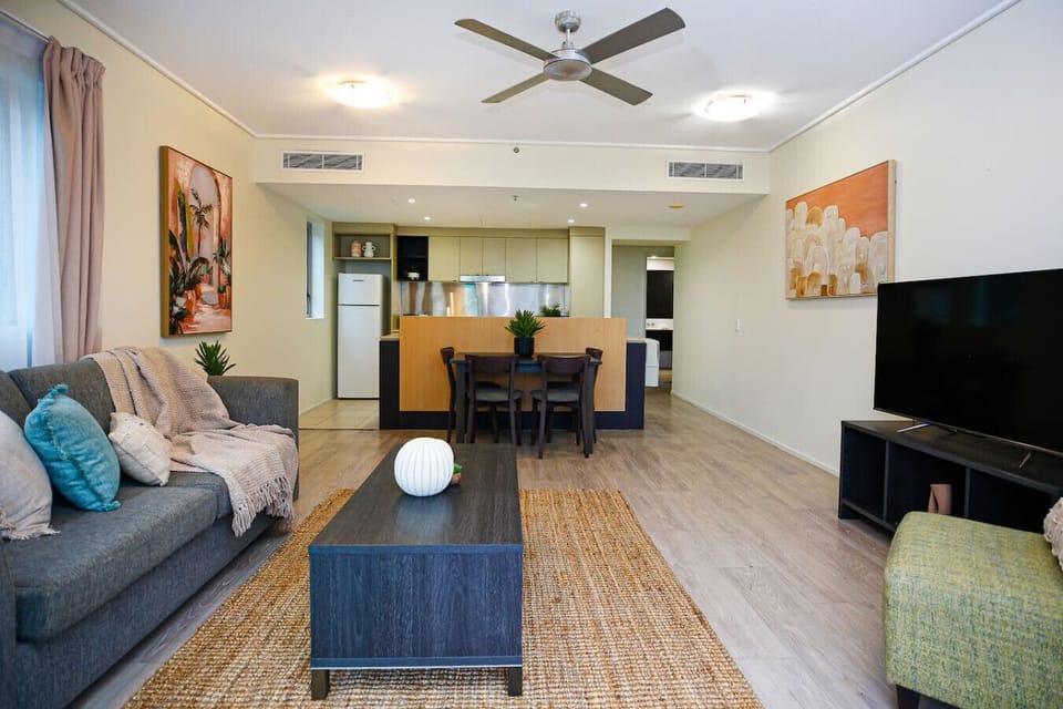 Step into a cozy and inviting living room with plush seating and a large TV—ideal for relaxing after a sunny day on the Esplanade. Let the tropical breeze in through sliding doors that open to your private balcony.