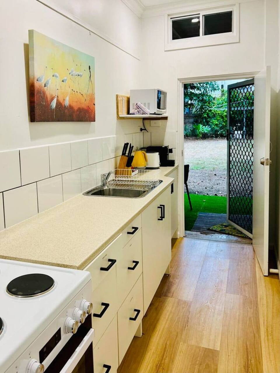 The unit features a full kitchen with modern appliances including a stove, oven, microwave, and fridge. It offers ample counter space and comes fully equipped with cookware and utensils, making it easy and convenient to prepare meals during your stay