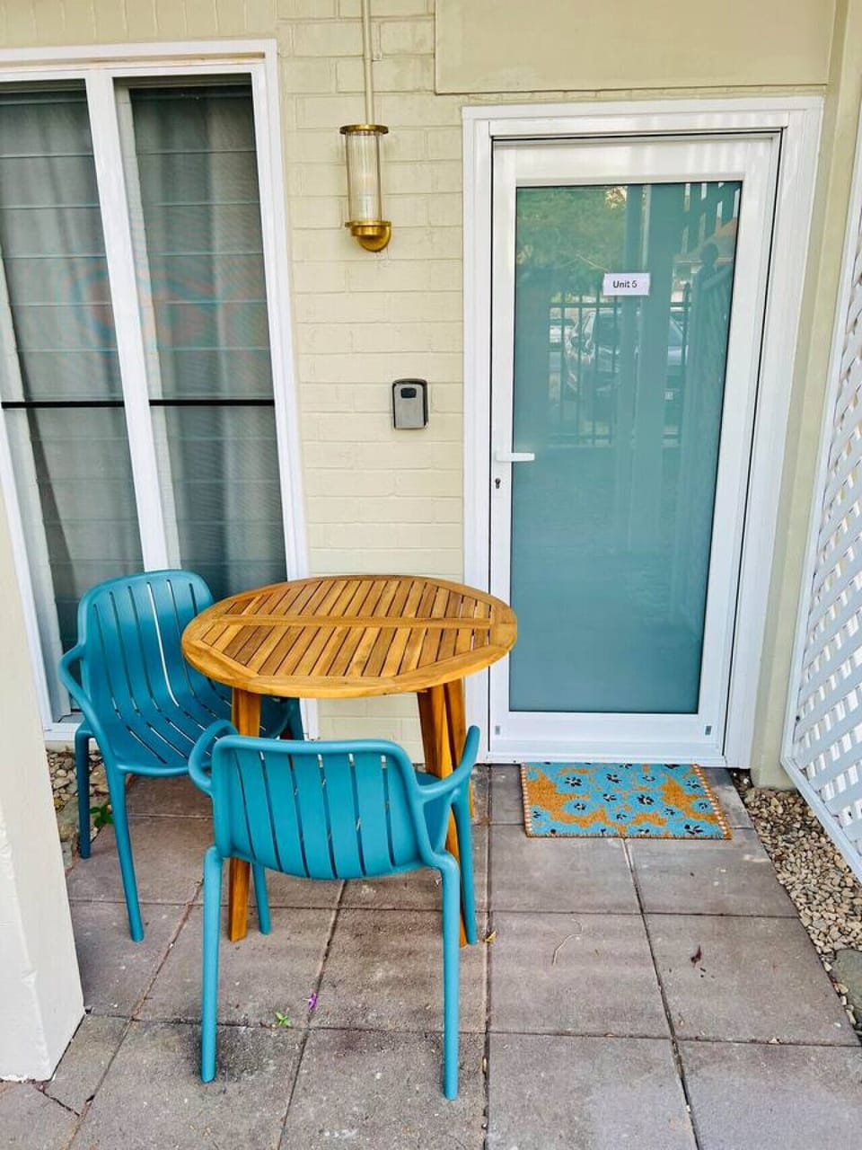 The front yard entrance features a cozy seating area with a small table and two chairs—perfect for enjoying your morning coffee or a relaxing moment outdoors. A charming spot to start your day or unwind in the fresh air.