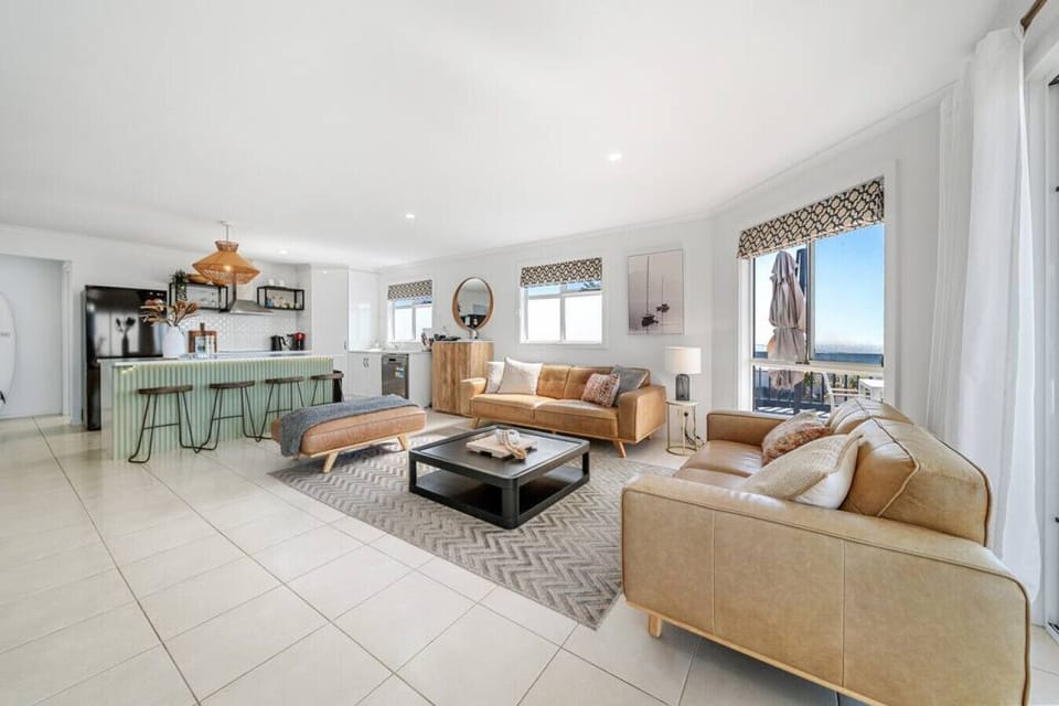 Stretch out on the lounge as natural light pours through large windows framing the ocean beyond.