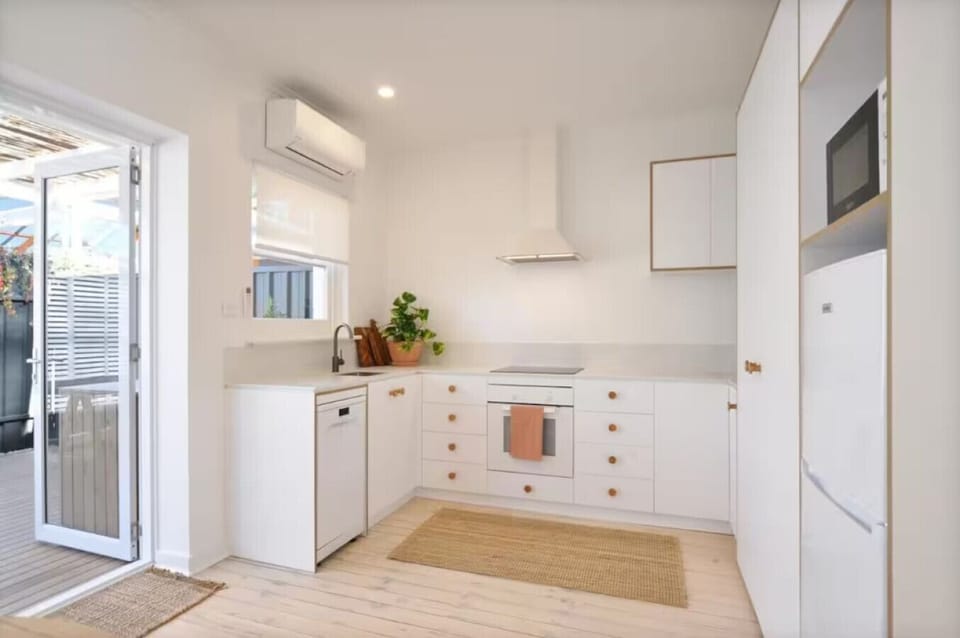 The compact, fresh white kitchen offers everything you need to whip up meals at home.