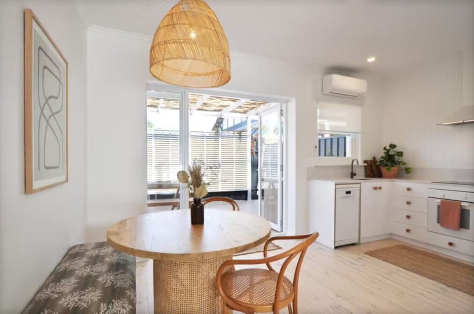Bench seating and classic timber chairs meet under soft pendant lighting—stylish and simple.