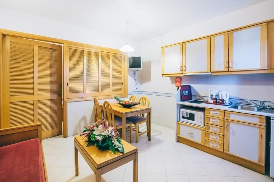 Cook simple meals with microwave, sink, and dining space nearby.