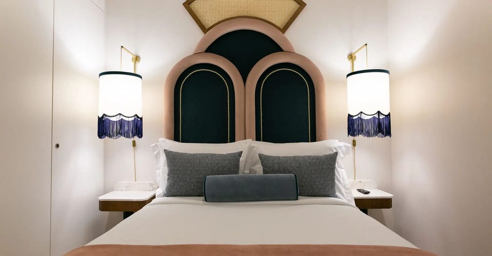 Sink into crisp sheets framed by elegant bedside lighting.