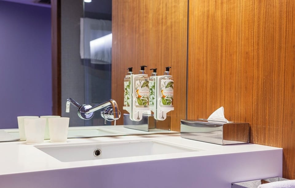 Refresh under soft lighting with premium soaps and sleek sink.