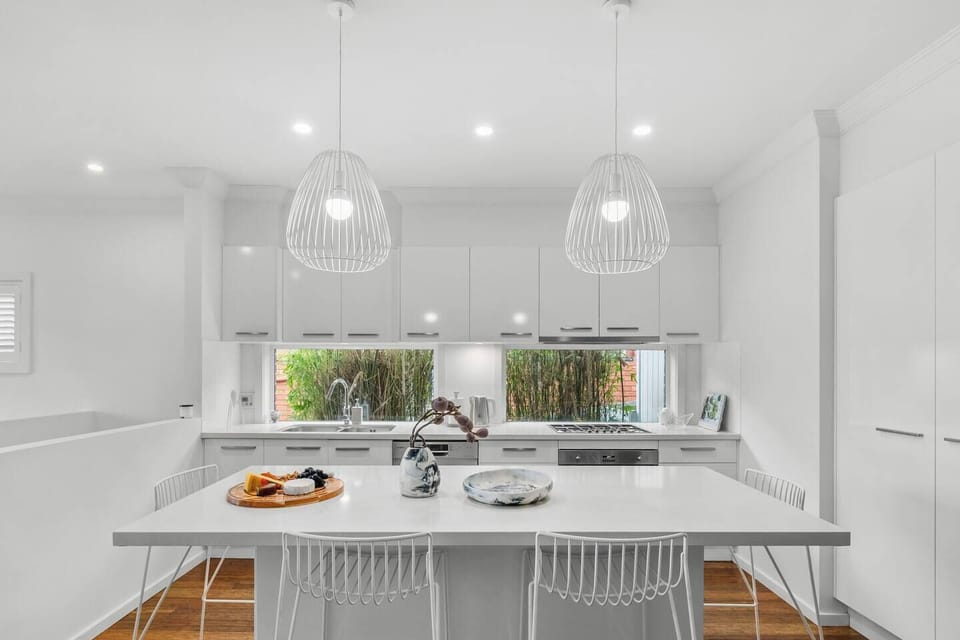 Gather around the kitchen island beneath pendant lighting, the perfect spot for morning coffees and casual meals.