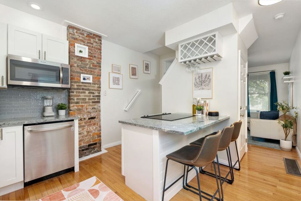 Kitchen island with quartz countertops, stainless appliances, and bar seating.