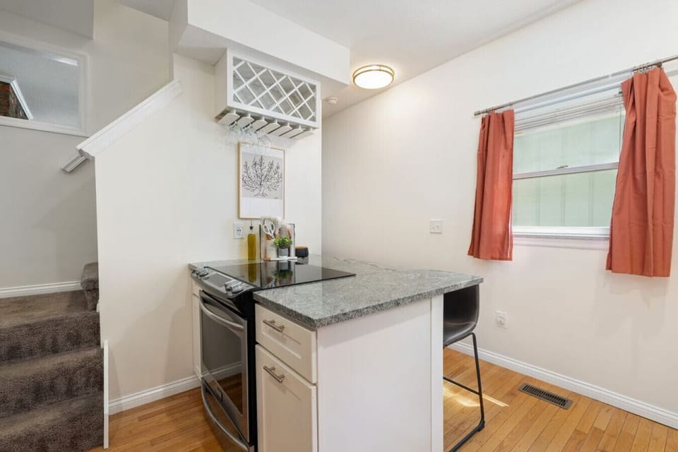 Updated kitchen with peninsula seating and stairs leading to the bedrooms.
