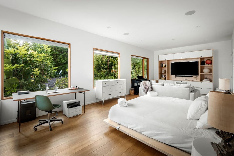 Your versatile retreat with a small workspace, comfy sofa, TV, and bedroom area.