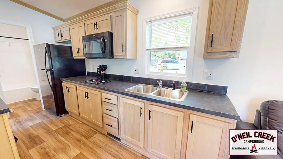 Kitchen w/ microwave, stove top, and fridge/freezer.
