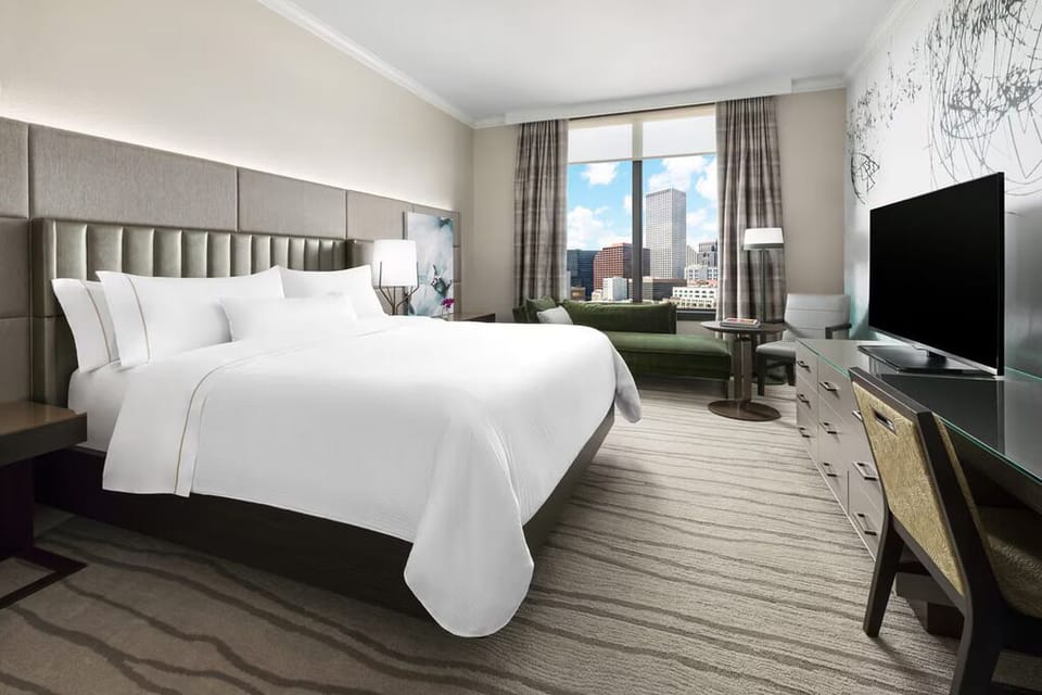 Unwind in crisp linens with sweeping city skyline views.