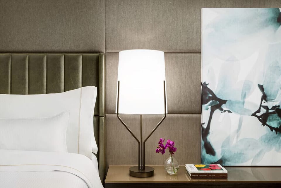 Unwind in crisp linens beneath soothing, designer lighting.