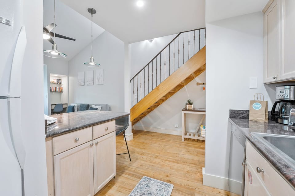 Open kitchen flows seamlessly into the living area with loft-style stairs and modern finishes.