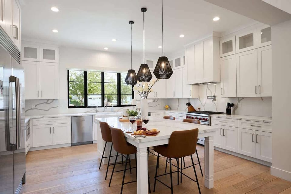 Fully equipped kitchen with stainless steal appliances, mini fridge, and a kitchen island with bar seating for 5 guests.