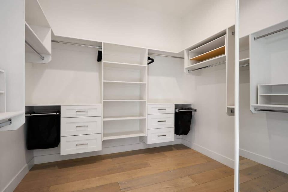 Primary Bedroom featuring a King bed, designer furnishings, walk in closet, en-suite bathroom, and backyard access.