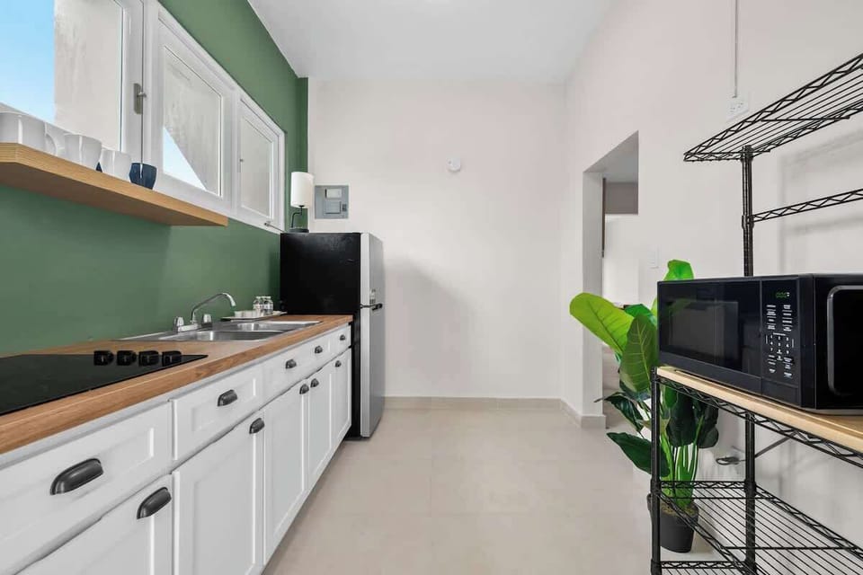 A pristine, fully equipped kitchen with a full-size refrigerator.


