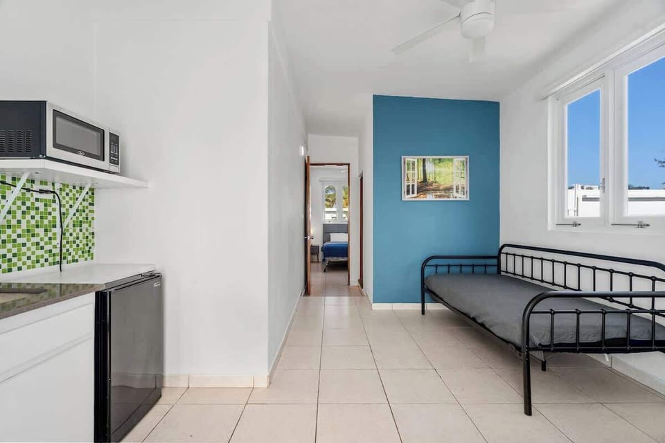 A well-lit common area with a TV and access to the bathroom. Simple and inviting.