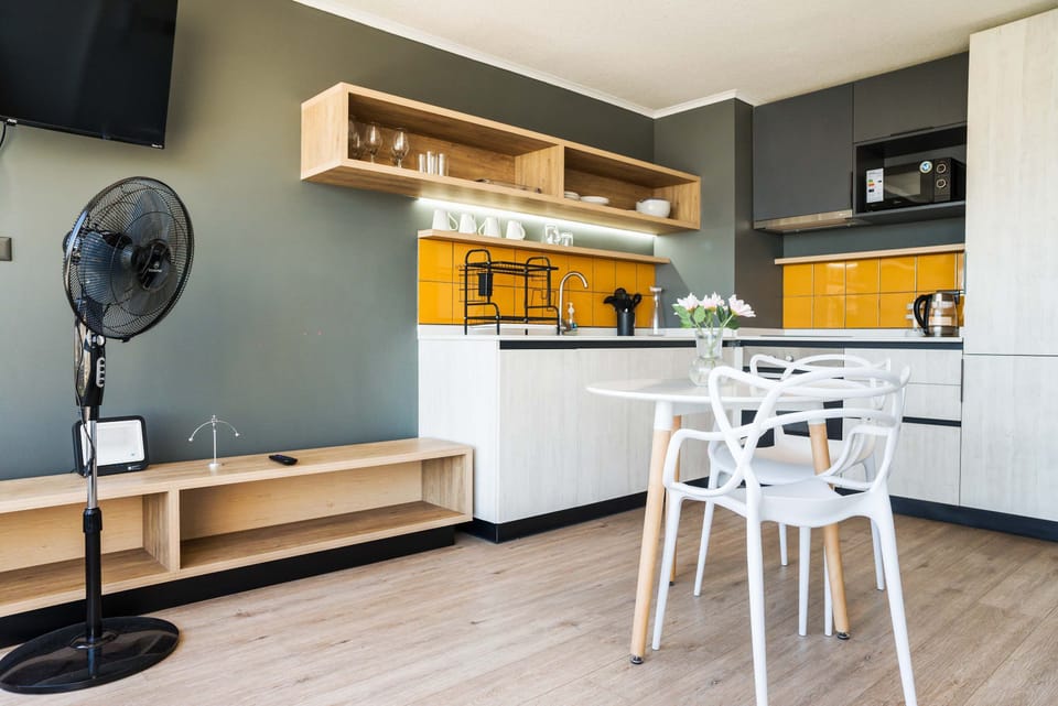 Stylish kitchen with vibrant yellow accents and cozy dining area, ideal for intimate meals.