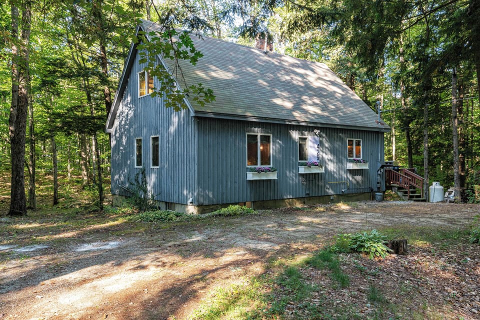 Exterior view of the house, including U shaped driveway and ample parking.