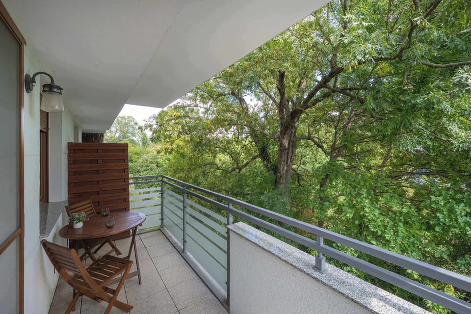 A balcony surrounded by trees offering a natural outlook. A peaceful spot to relax outdoors.