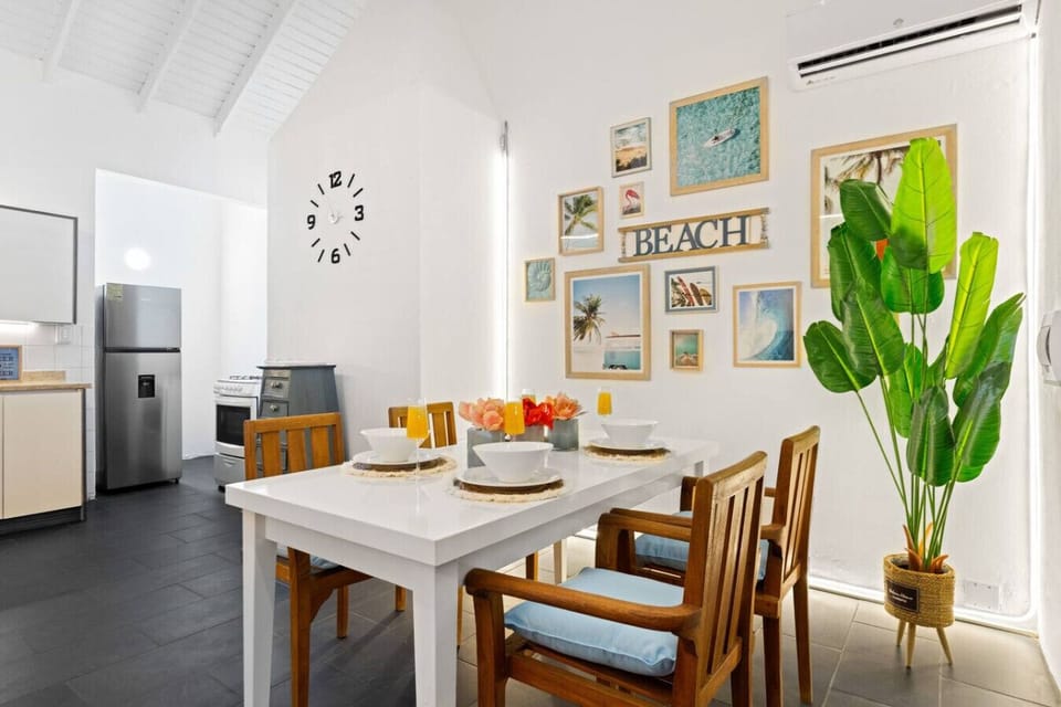 Dining table set for six with beachy wall art and bright light