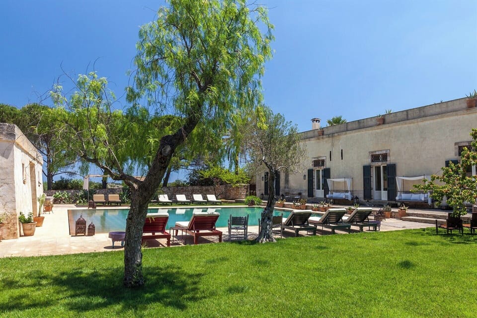 Large expanses of lawn surround the pool and the house.
