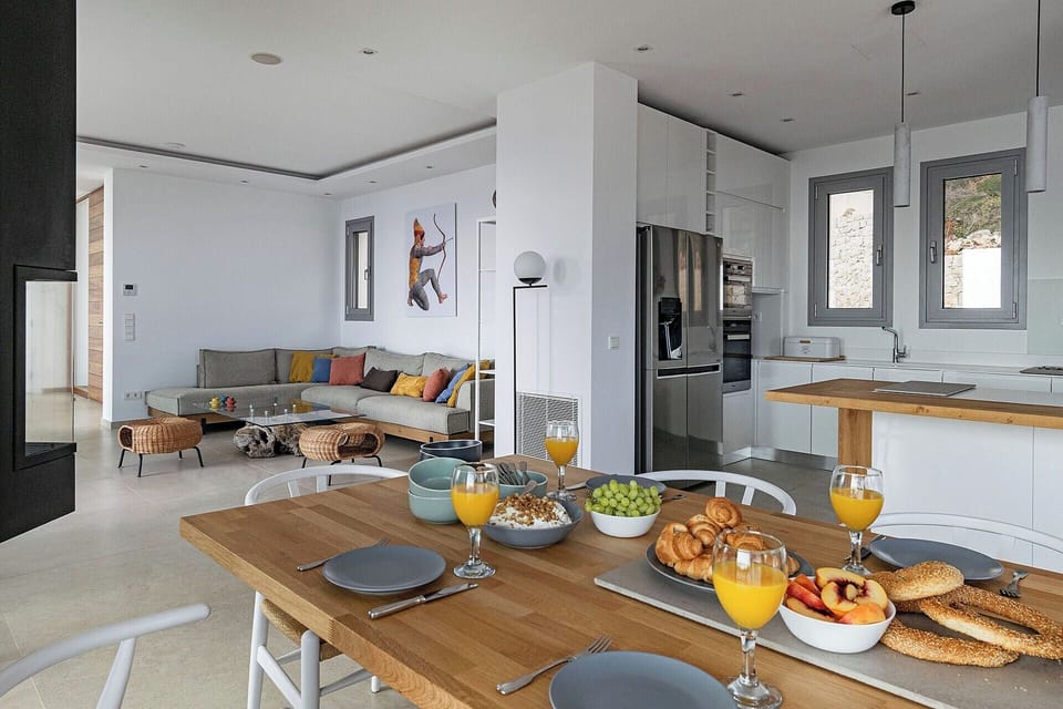 A view of the open-concept communal space with the dining area, kitchen and sofa.