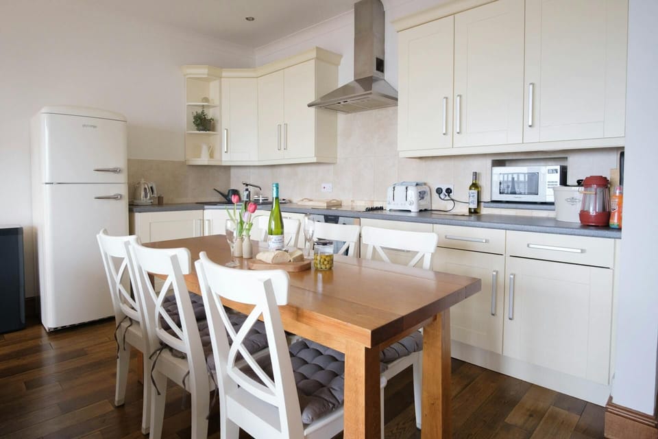 Kitchen with fridge/freezer, electric oven and hob, toaster, microwave, kettle, dining table with six chairs