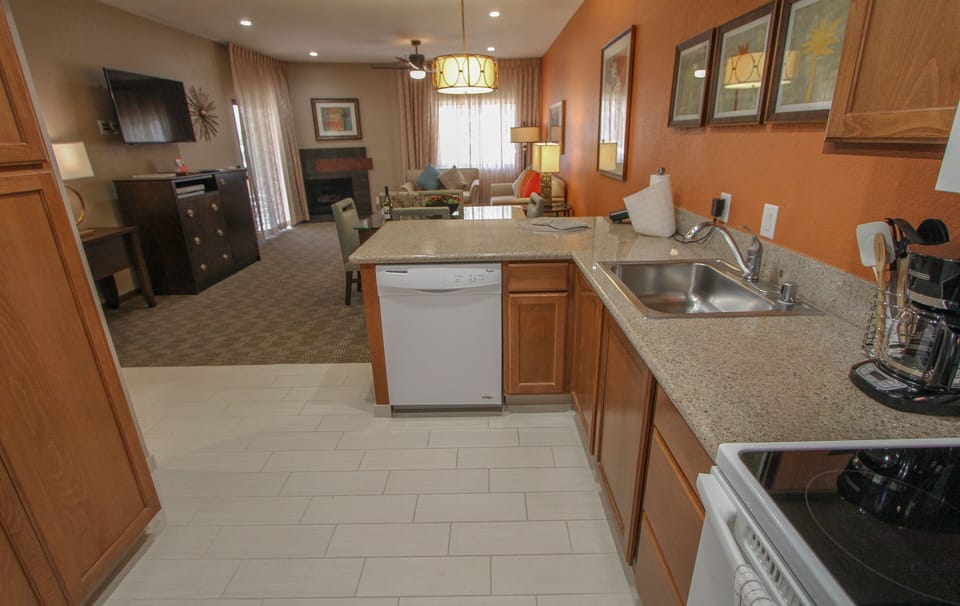 This inviting kitchen features modern appliances and a convenient layout, seamlessly connecting to the cozy living area adorned with tasteful decor.
