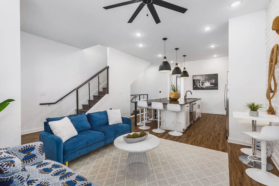 Living room with two comfy couches, a ceiling fan, and a Smart TV with all the streaming apps. Lots of natural light in this home with unique decor highlighting Nashville`s roots in music.