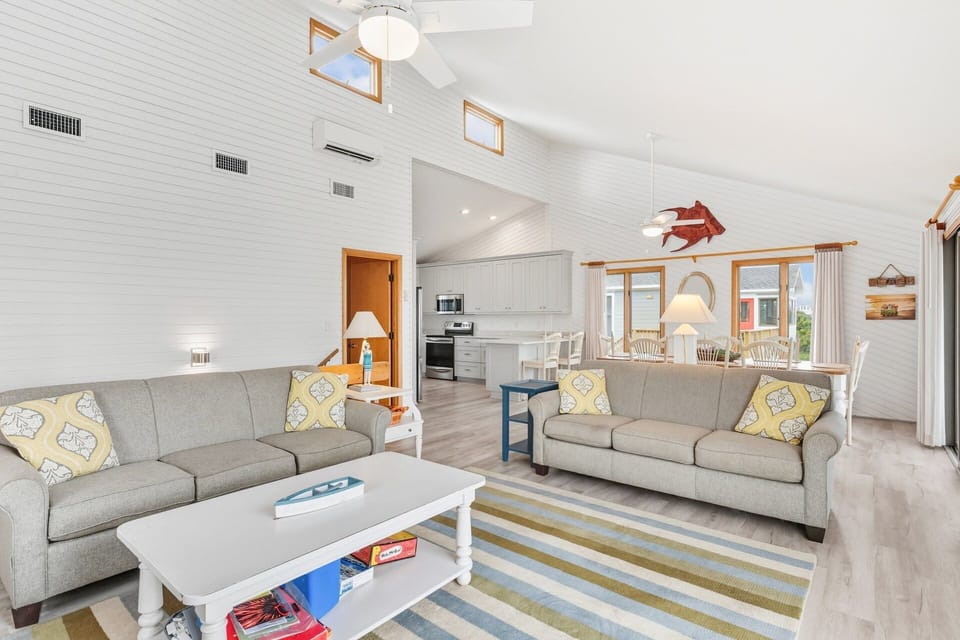 Gather together in the spacious living room with plush seating, ocean views, and easy deck access.
