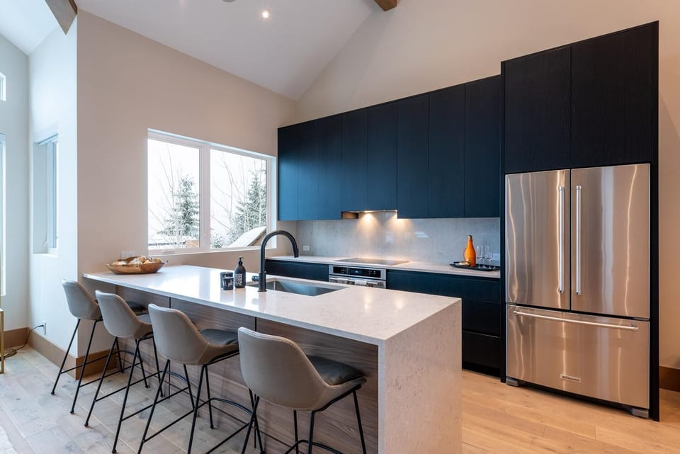 Modern kitchen with 4 barstools, induction range, fridge/freezer with ice maker, dishwasher