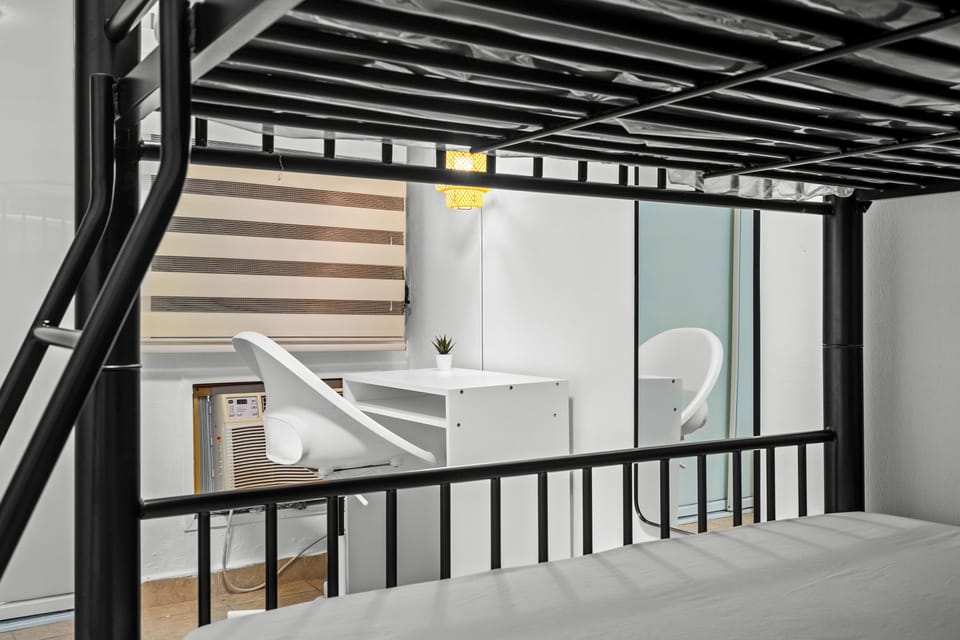 Peek into the study space under the top bunk, a clever use of space perfect for reading or catching up on work, bathed in natural light.